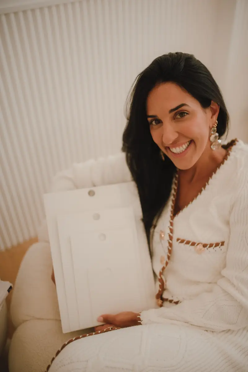 Ive Bitencourt smiling while holding a downsizing plan during a consultation